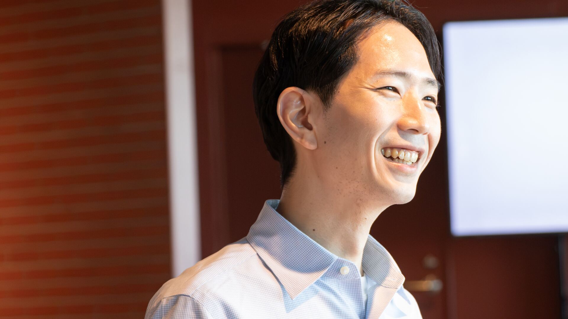 冊子を手に、笑顔で話す野原倫久